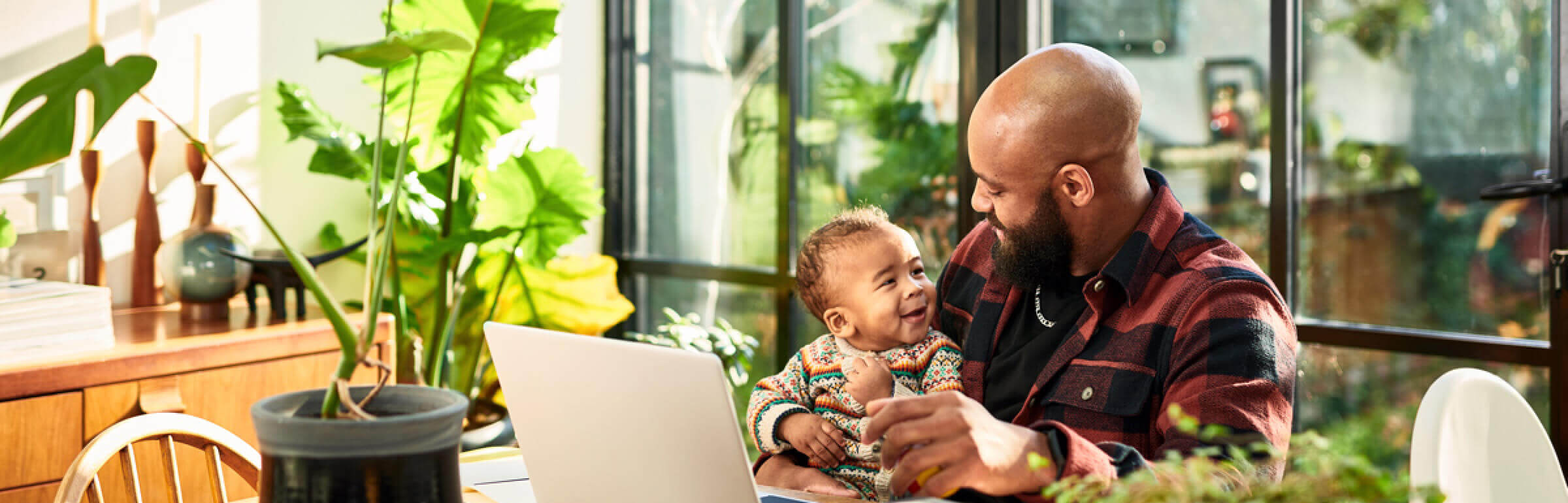 Man with baby in front of laptop