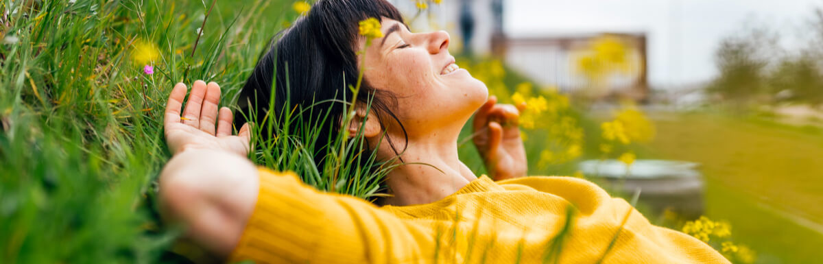 lady in yellow top laying in the grass