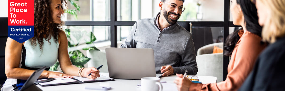 office workers around table shaking hands