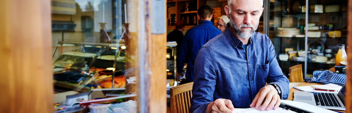Small businessman lookng at papers at desk