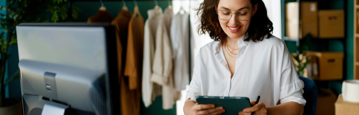smiling businesswoman on tablet in warehouse 