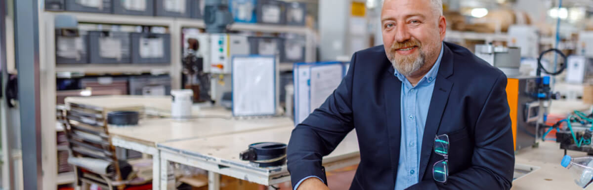smiling senior business owner in factory warehouse