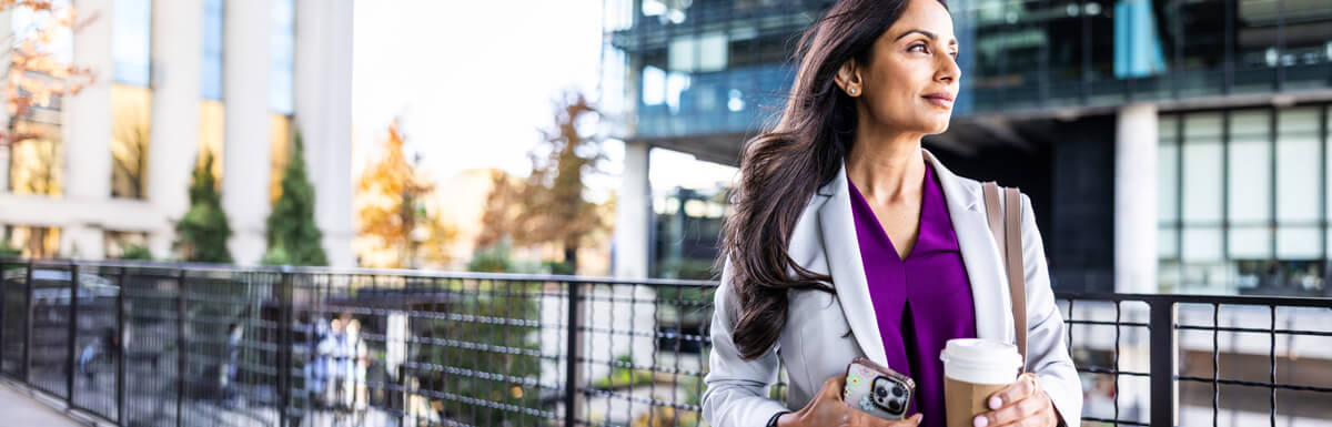 Smiling woman in city with coffee